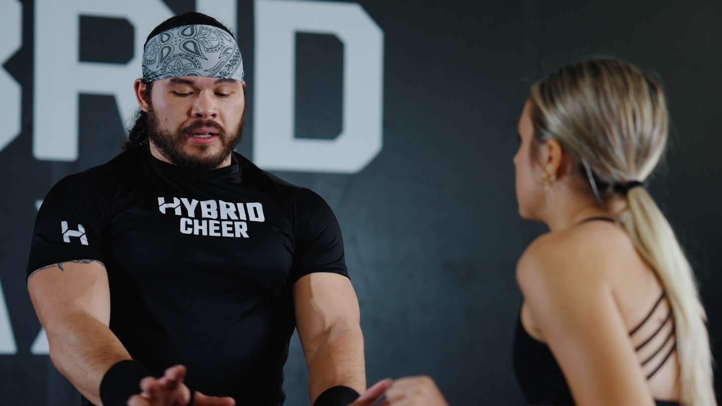 Kollin Cockrell teaching a cheerleader coed stunting